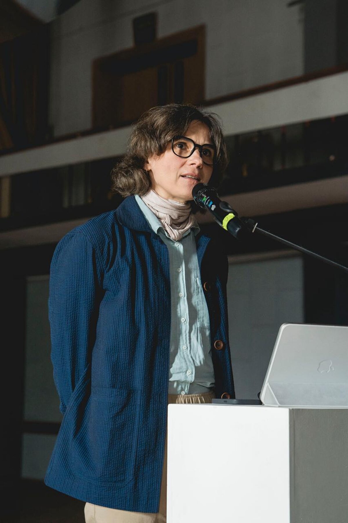 Attēlā pie mikrofona redzama projekta pētniece Anita Zariņa. Attēlā pie mikrofona redzama projekta pētniece Anita Zariņa.